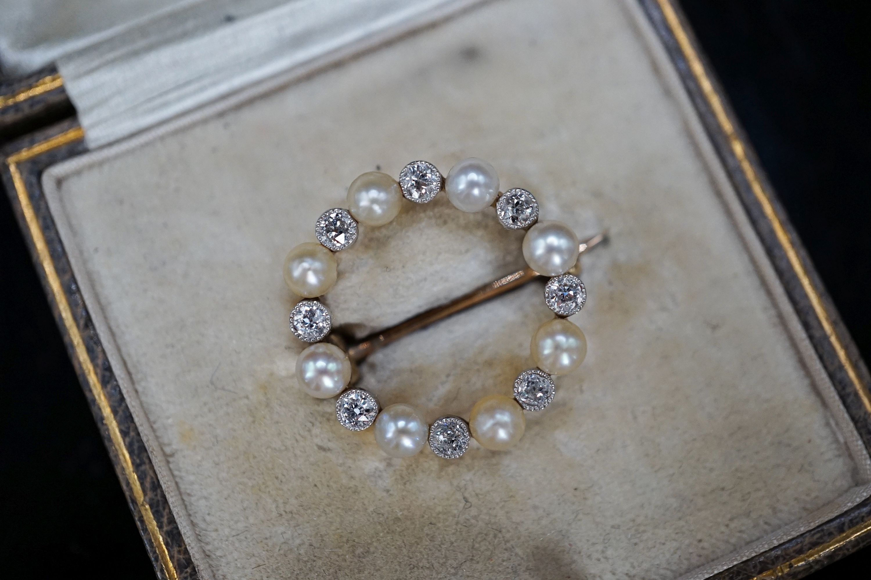 An Edwardian yellow metal, diamond and seed pearl set open work circular brooch, 20mm, gross 2.9 grams.
